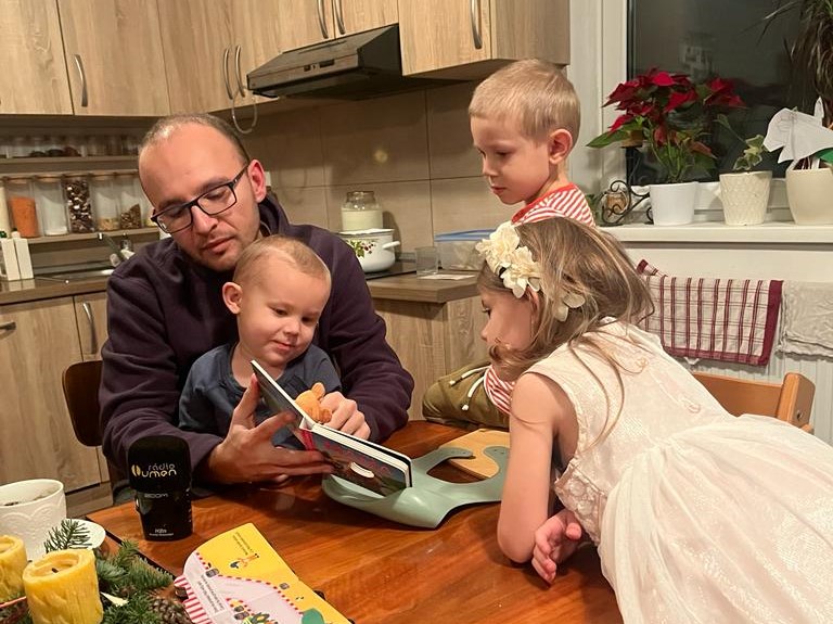 Redaktor Ivo Novák počas návštevy v Lokci číta deťom darované knižky